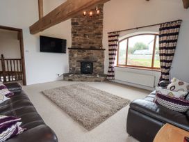 A living room with a fireplace and a sofa at Horse and Farrier Barn in Newton in Cartmel near Cartmel