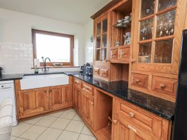 A kitchen with wood cabinets and a sink at Horse and Farrier Barn, Newton in Cartmel near Cartmel