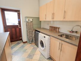 A kitchen with a washing machine and a sink at Horse and Farrier Barn, Newton in Cartmel near Cartmel