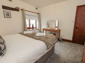 A bedroom with a bed and a mirror at Horse and Farrier Barn in Newton in Cartmel near Cartmel