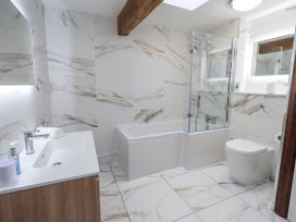 A bathroom with a bathtub, toilet, and sink at Horse and Farrier Barn in Newton in Cartmel near Cartmel