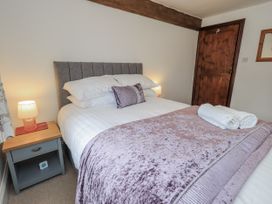 A bedroom with a bed and bedside table at Horse and Farrier Barn in Newton in Cartmel near Cartmel