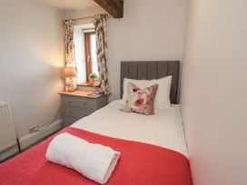 A bedroom with a bed and a nightstand at Horse and Farrier Barn in Newton in Cartmel near Cartmel