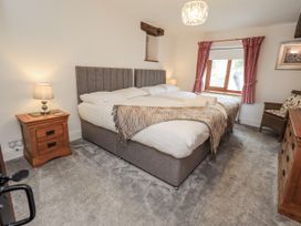 A bedroom with a bed and lamp at Horse and Farrier Barn in Newton in Cartmel near Cartmel