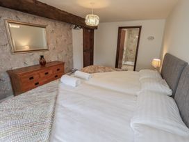A bedroom with two beds and a dresser at Horse and Farrier Barn in Newton in Cartmel near Cartmel