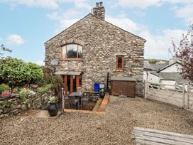 A stone house exterior with plants and a gravel area at Horse and Farrier Barn, Newton in Cartmel near Cartmel