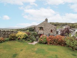 A garden with flowers and a house at Horse and Farrier Barn, Newton in Cartmel near Cartmel