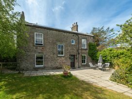 A stone house with a patio and garden furniture at Wonderland in Tweedmouth, Berwick-Upon-Tweed