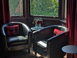 Two chairs and a table with flowers in a sitting room at Wonderland in Tweedmouth, Berwick-Upon-Tweed
