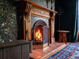 A living room with a fireplace and wooden table at Wonderland in Tweedmouth, Berwick-Upon-Tweed