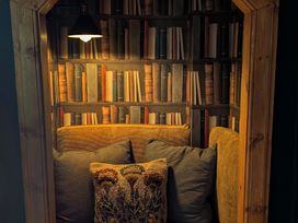 A reading nook with a sofa and lamp at Wonderland in Tweedmouth, Berwick-Upon-Tweed