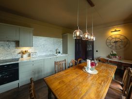 A kitchen with cabinets and a dining table at Wonderland in Tweedmouth, Berwick-Upon-Tweed