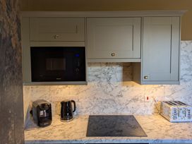 A kitchen with a microwave, kettle, coffee maker, and toaster at Wonderland, Tweedmouth, Berwick-Upon-Tweed