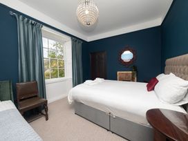 A bedroom with a bed and chair at Wonderland, Tweedmouth, Berwick-Upon-Tweed