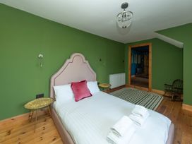 A bedroom with a bed, side tables, and a rocking chair at Wonderland in Tweedmouth, Berwick-Upon-Tweed