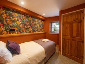 A bedroom with a bed and patterned wall at Wonderland in Tweedmouth, Berwick-Upon-Tweed