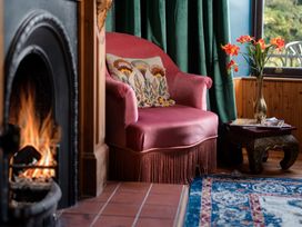 A living room with an armchair and a fireplace at Wonderland Tweedmouth, Berwick-Upon-Tweed