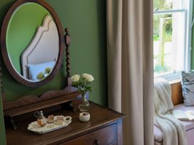 A bedroom with a dresser and flowers at Wonderland in Tweedmouth, Berwick-Upon-Tweed