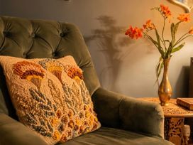 A chair with a cushion and a vase of flowers at Wonderland in Tweedmouth, Berwick-Upon-Tweed