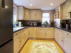 A kitchen with light wood cabinets black countertops a patterned rug and various kitchen appliances at Wayford Mill in Wayford