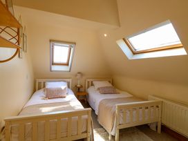A bedroom with two single beds and slanted roof windows at Wayford Mill in Wayford