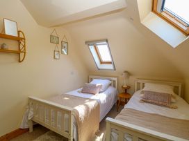 A bedroom with two single beds side by side under skylight windows at Wayford Mill in Wayford