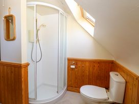 A bathroom with a corner shower cubicle a toilet and a wall mirror at Wayford Mill in Wayford