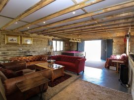 A room with leather and fabric sofas a wooden coffee table a pool table and framed fish pictures at Wayford Mill in Wayford