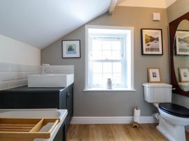 A bathroom with a bathtub sink window toilet and framed pictures at Glan yr Afon in Abergynolwyn near Tywyn