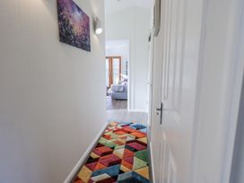 A hallway with a colorful rug leading to a living area at JacMar Lodge, 14 Applethwaite, Limefitt Park near Windermere