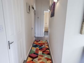 A hallway with a colorful rug and doors at JacMar Lodge 14 Applethwaite Limefitt Park near Windermere