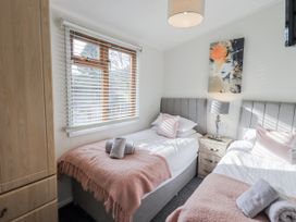 A bedroom with twin beds and a window at JacMar Lodge, 14 Applethwaite, Limefitt Park near Windermere