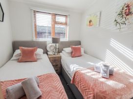 A bedroom with two beds and a nightstand at JacMar Lodge 14 Applethwaite Limefitt Park near Windermere
