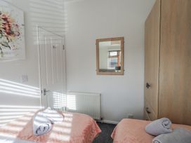 A bedroom with two beds and a mirror at JacMar Lodge, 14 Applethwaite, Limefitt Park near Windermere