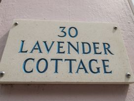 A stone house number plaque reading 30 Lavender Cottage on a pink wall at Lavender Cottage in Lyme Regis