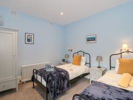 A bedroom with two single beds with bedside tables and lamps at The Garden Flat in Charmouth