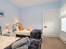 A bedroom with two single beds bedside table and lamps at The Garden Flat in Charmouth