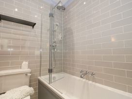 A bathroom with a bathtub a shower and a toilet at The Garden Flat in Charmouth