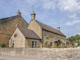A stone house with a wall and a sign at Robins Nest in Bourton-On-The-Water