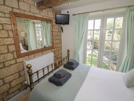 A bedroom with a bed and television at Robins Nest in Bourton-On-The-Water