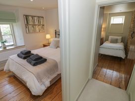 A bedroom with a bed, lamp, and towels at Robins Nest in Bourton-On-The-Water