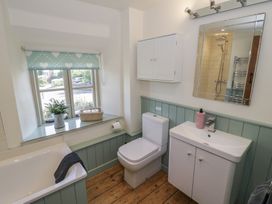 A bathroom with a bath tub, toilet, and sink at Robins Nest in Bourton-On-The-Water