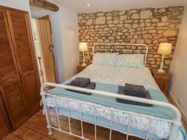 A bedroom with a bed and wooden furniture at Robins Nest in Bourton-On-The-Water