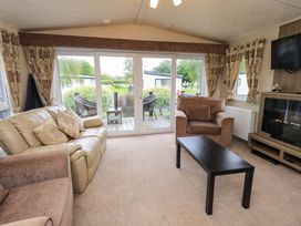 A living room with a sofa and armchair at 41, Grandma's Cottage near South Lakeland Leisure Village Carnforth