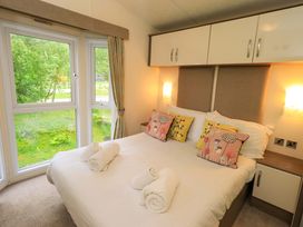 A bedroom with a bed and windows at 41, Grandma's Cottage South Lakeland Leisure Village near Carnforth