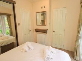 A bedroom with a bed and mirror at 41, Grandma's Cottage South Lakeland Leisure Village near Carnforth