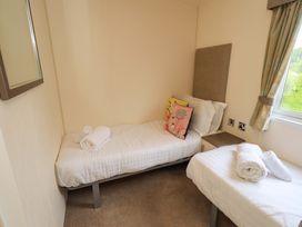 A bedroom with two single beds and a mirror at 41, Grandma's Cottage South Lakeland Leisure Village near Carnforth