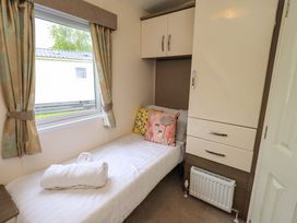 A bedroom with a bed and wardrobe at 41, Grandma's Cottage South Lakeland Leisure Village near Carnforth