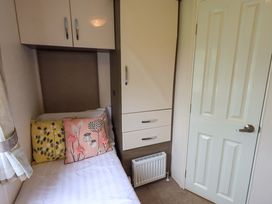 A bedroom with a bed and wardrobe at 41, Grandma's Cottage South Lakeland Leisure Village near Carnforth