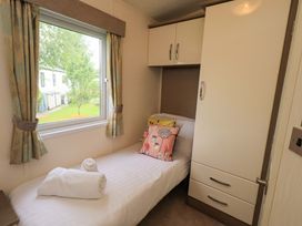A bedroom with a single bed and wardrobe at 41, Grandma's Cottage South Lakeland Leisure Village near Carnforth